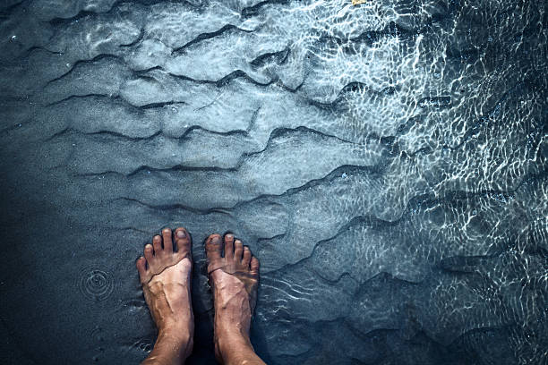 Feet of the person standing in the water